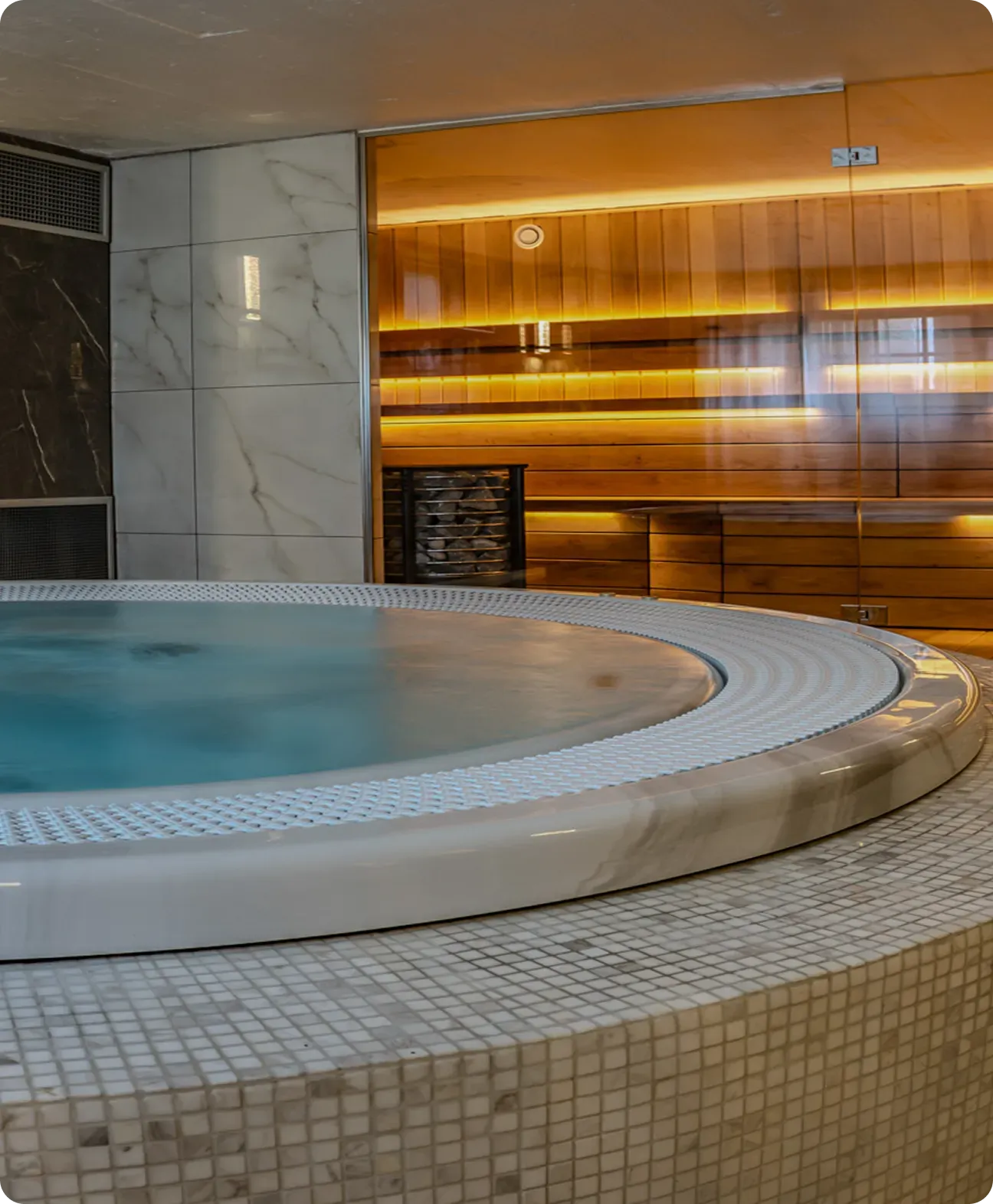 Jacuzzi framför en upplyst bastu.
